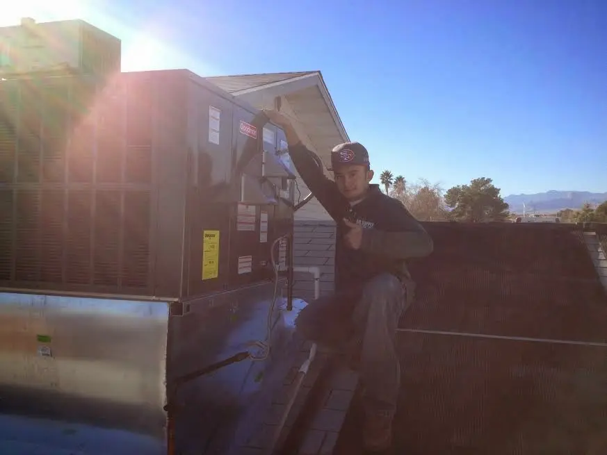 HVAC technician performing Air Duct Cleaning on a rooftop unit in Northdale